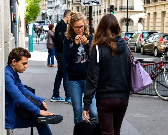 Lycéens sac à l'épaule sur un trottoir parisien, juste avant leur cours
